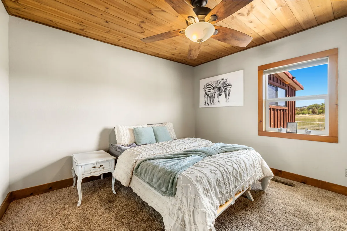This image captures a serene bedroom featuring a bed with cozy blankets, a window that lets in natural light, and zebra-themed art on the wall. The overall ambiance is inviting and peaceful, ideal for relaxation after a busy day.